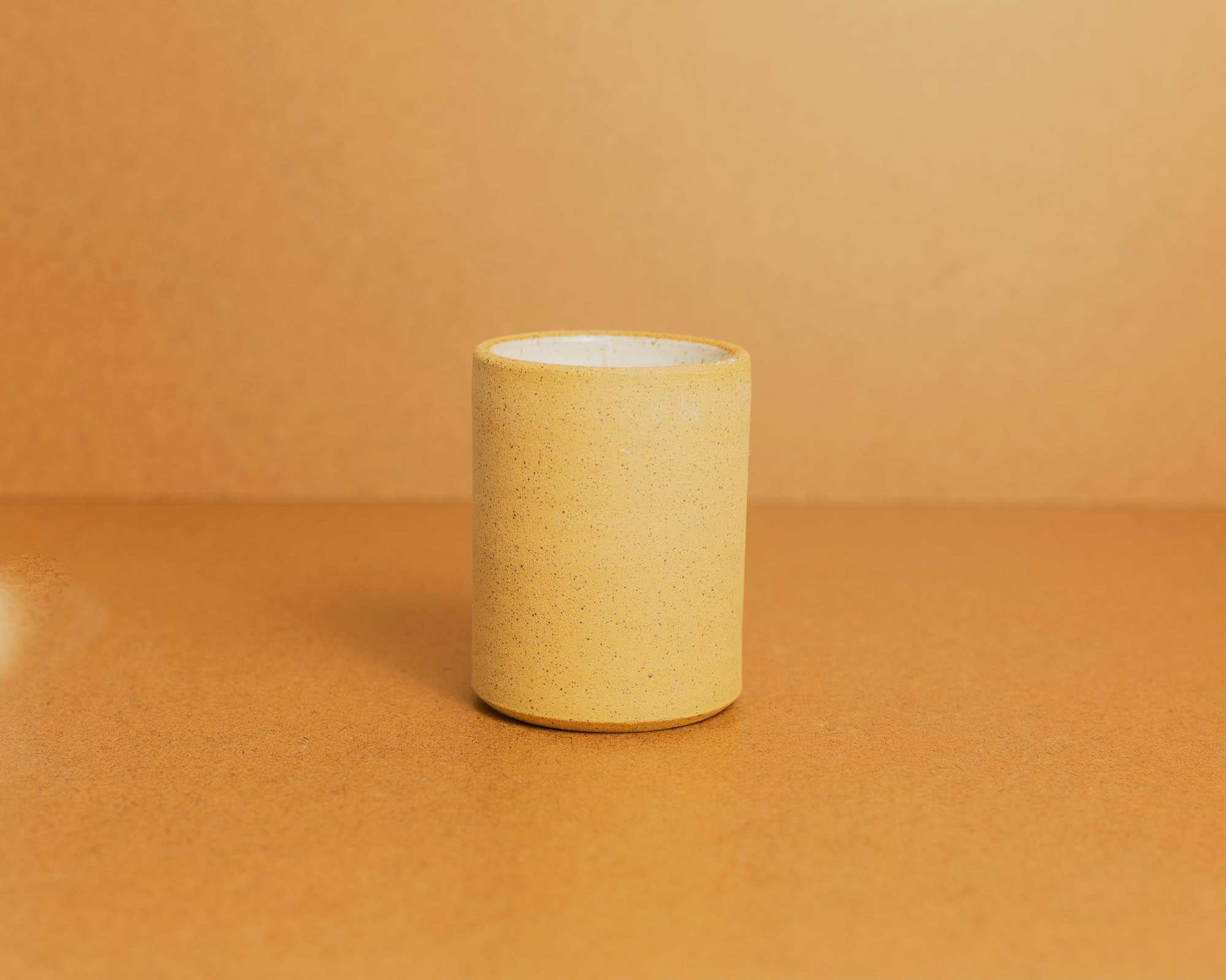 Natural clay ceramic candle on a brown background