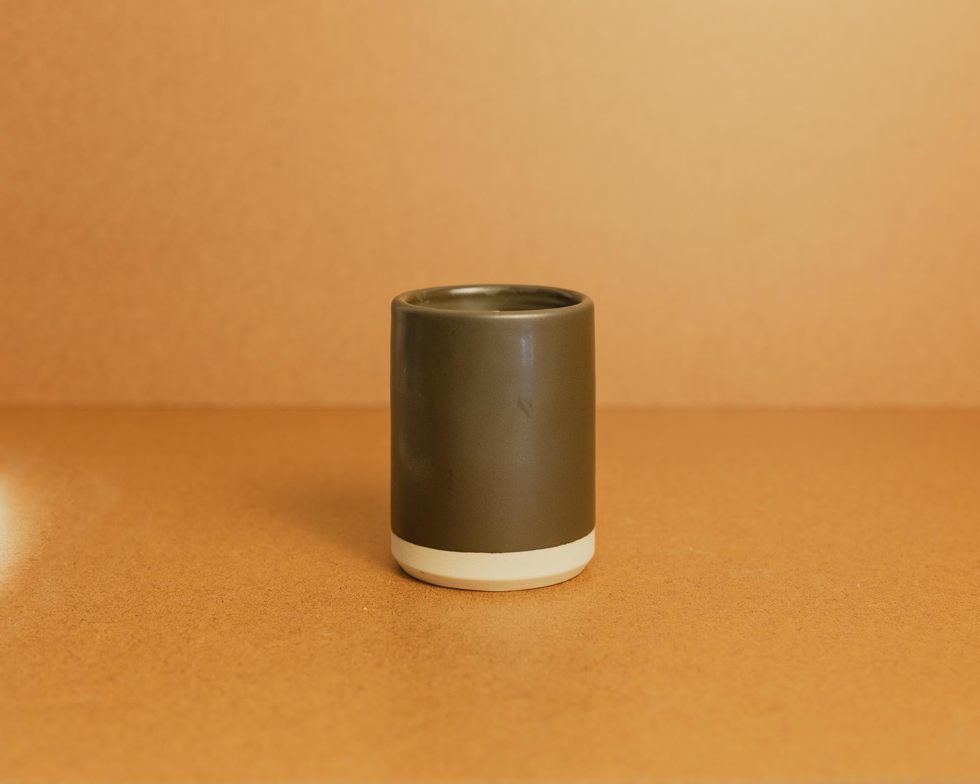 Brown ceramic candle with a gradient design on a brown background