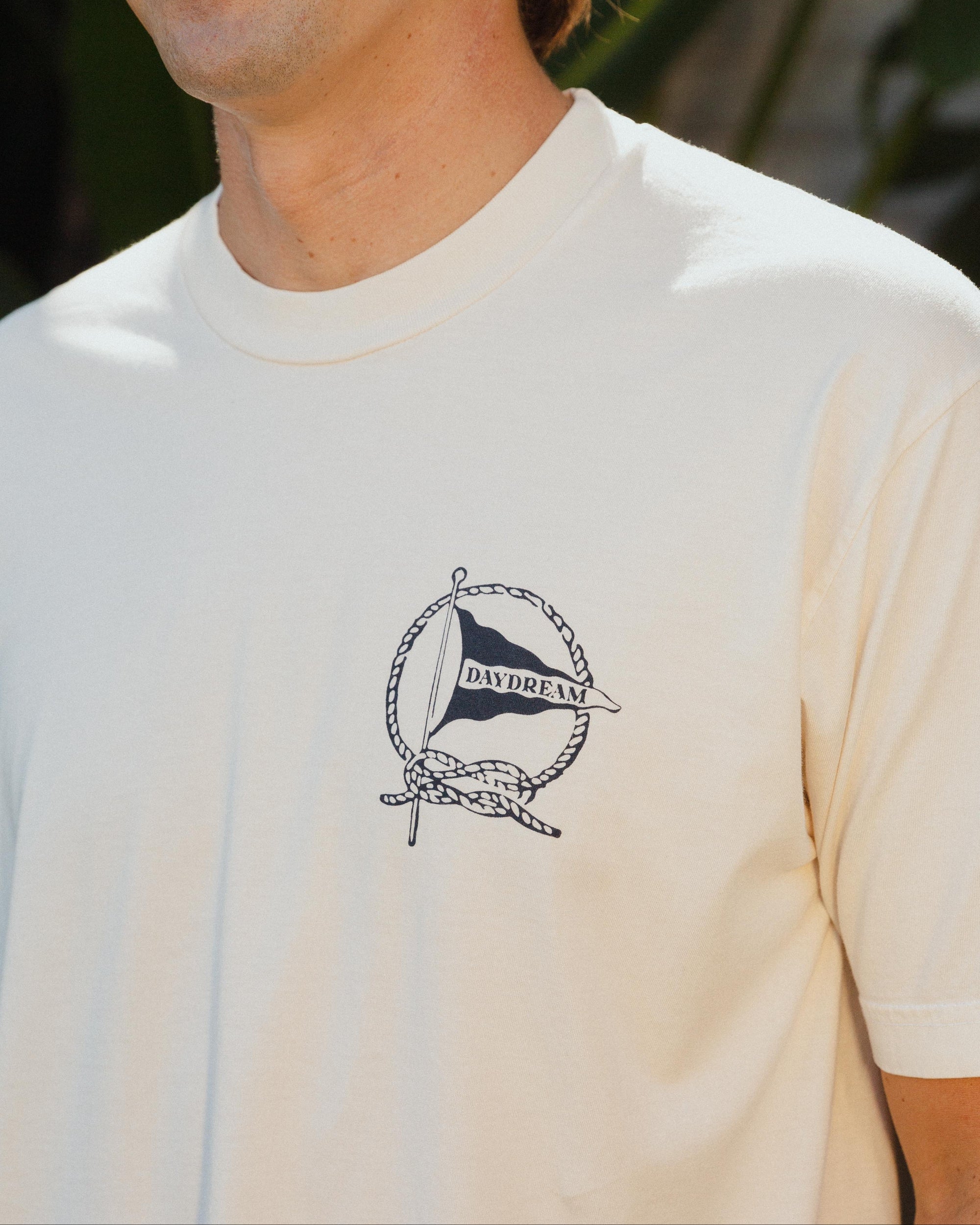 Man wearing a white t-shirt with a Daydream Surf Shop logo