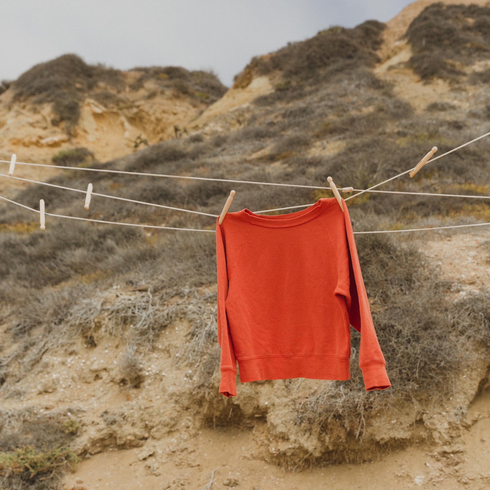 Women&#39;s Raglan Crew in Red on Clothing Line at Beach