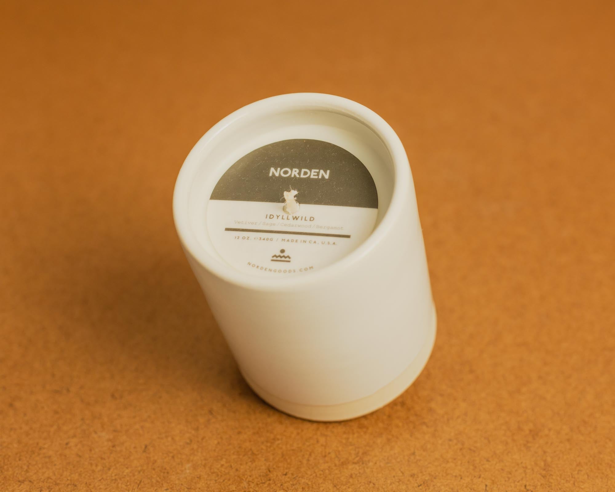 White ceramic candle on a brown background