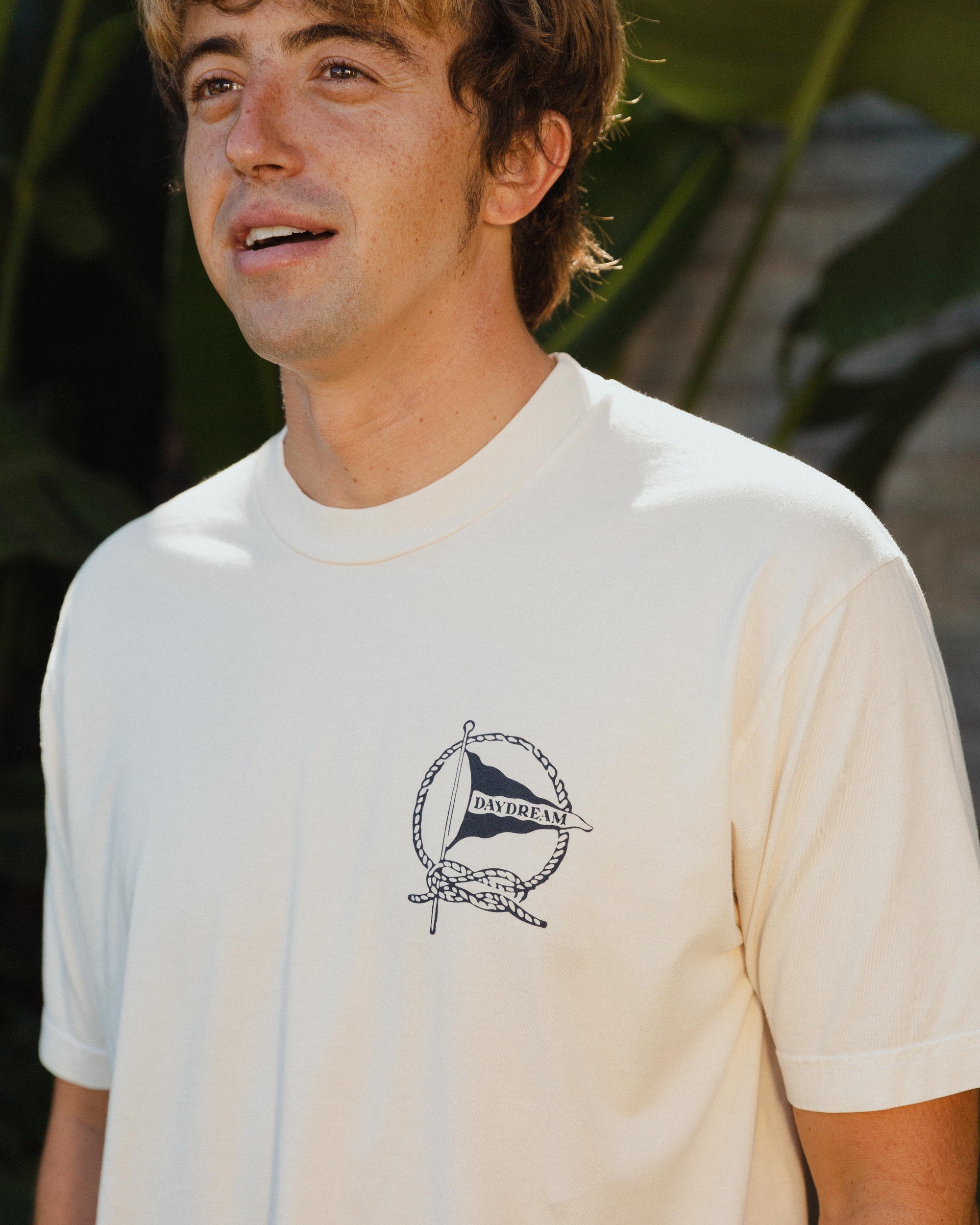 Man wearing a white t-shirt with a Daydream Surf Shop logo