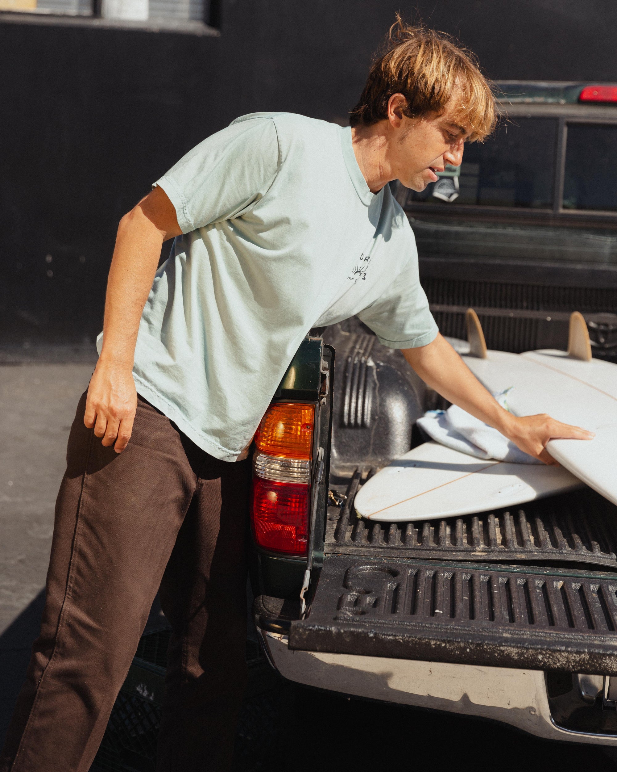 Person loading surfboards into a truck bed